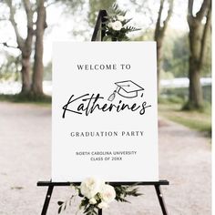 a welcome sign for a graduation party with flowers and greenery on the bottom of it