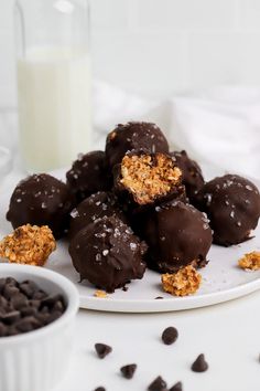 chocolate covered cookies on a plate next to a glass of milk