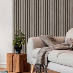 a living room with striped wallpaper and a white couch next to a wooden table