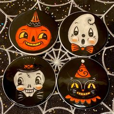 four halloween plates with faces painted on them