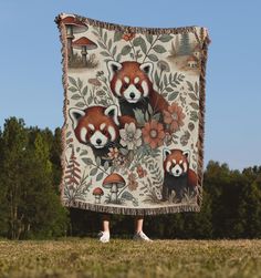 a woman standing in front of a tapestry with red pandas on it's back