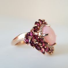 Peruvian Pink, Opal. Orissa, Rhodolite Garnet. White Zircon. Ring. Size (6). Vermeil Rose Gold Over Sterling Silver. Peruvian Pink Opal. Oval. (119) Mm. Height (23) Width (24) Mm. Orissa Rhodolite Garnet. Rounds And Marquise Cut. (26) Ct. Zircon Rounds (22) Ct. Prong Set. Beautiful Peruvian Pink Opal, Surrounded With Halo Of Orissa Rhodolite Garnet. Gorgeous Blend Of Gemstones And Color's. Pastel Pink's. Purplish Pink's, Rosey Reds. Wine. Chardonnay. White Shimmering Zircons. Boutique. Celestial Pink Opal Ring, Rhodolite Garnet Ring, Gold Tassel Necklace, Statement Bib Necklace, Daisy Necklace, Beaded Tassel Earrings, Gold Rings Fashion, Daisy Earrings, Gold Heart Necklace