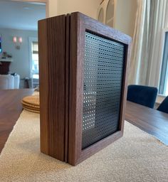 a wooden speaker sitting on top of a carpeted floor