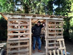 a man standing in front of a wooden structure