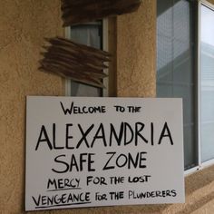 a sign on the side of a building that says, welcome to alexandria safe zone merry for the lost