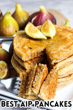 a stack of pancakes sitting on top of a white plate next to sliced figs