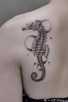 a woman's back with a tattoo on her shoulder and a seahorse in the middle