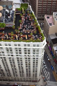 an aerial view of the roof of a tall building with tables and chairs on it