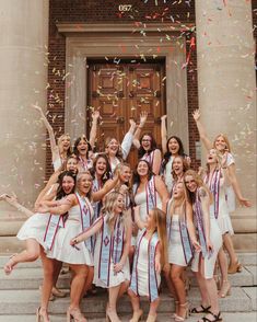 a group of young women standing next to each other in front of a building with confetti