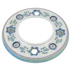 a white and blue circular object with flowers on it's sides, surrounded by smaller circles