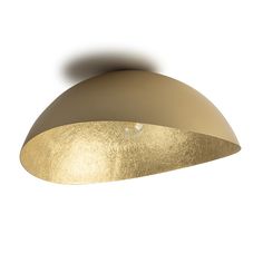 a light that is on the side of a white wall with a gold dome shade