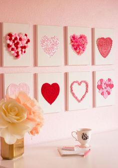 there are many hearts on the wall and a vase with flowers in front of it