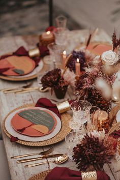 the table is set with red and gold place settings