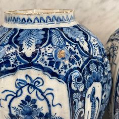 two blue and white vases sitting next to each other