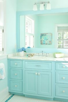 a bathroom with blue cabinets and white counter tops