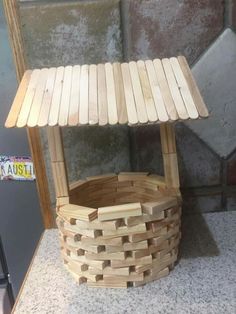 a wooden stand with a basket underneath it on a counter top next to a mirror