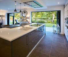 a large kitchen with an island counter top next to a sliding glass door that leads outside