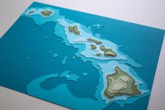 a piece of paper cut out to look like a map with mountains and lakes on it