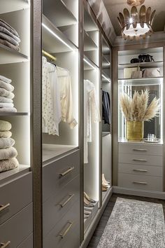 a walk in closet filled with lots of drawers and white clothes on top of shelves