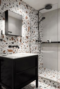 a bathroom with a sink, mirror and shower stall in the background is an artistically designed wallpaper