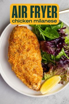 an air fryer chicken meal on a plate with lettuce and lemon wedges