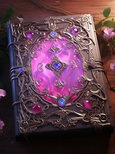 a purple and blue book sitting on top of a wooden table next to pink flowers