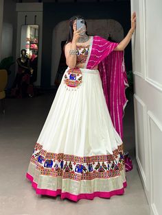 Celebrate Navratri in style with this stunning lehenga choli set. The lehenga is crafted from pure rayon, featuring a 5-meter flair with intricate Gamthi work and a delicate lace border, creating a flowy, elegant silhouette. The blouse is adorned with Gamthi work, paper mirror detailing, and Cowrie (Kodi) lace, offering a beautiful blend of traditional artistry and contemporary design. The soft silk dupatta with a Leheriya print and lace border adds a pop of color and grace, perfectly complementing the outfit. To complete the ensemble, a matching purse with Gamthi work and Cowrie lace is included, making it both practical and stylish. Making it an ideal choice for Garba nights and Navratri celebrations.  #NavratriFashion #LehengaCholi #GarbaOutfit #EthnicWear #RayonLehenga #GamthiWork #Leh Leheriya Dupatta, Gamthi Work, Zip Stitching, Garba Dress, Ghaghra Choli, Dupatta Style, Navratri Dress, Cotton Lehenga