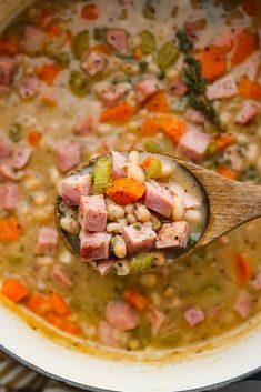 a wooden spoon full of ham and bean soup