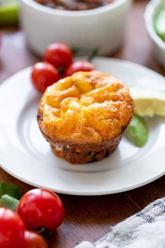 there is a small pie on the plate with tomatoes and cucumbers around it