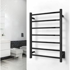 an image of a bathroom setting with black and white accessories on the wall, and a towel rack in the middle