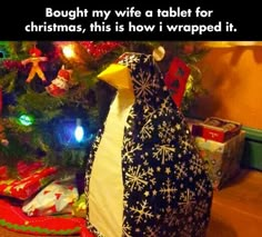 a penguin sitting in front of a christmas tree with presents under it and the caption says, bough my wife a table for christmas, this is how i wrapped it