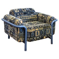 an upholstered chair with blue metal legs and patterned fabric on the armrests