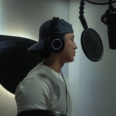 a young man wearing headphones in front of a microphone