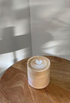 a cappuccino sitting on top of a wooden table