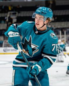 a hockey player is standing on the ice with his stick in hand and looking at the camera