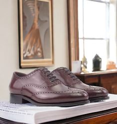 Also known as a wingtip, the Full Brogue is easily identifiable as one of the most classic pairs of men's dress shoes on the market. Featuring a brogue pattern along the sides as well as the toe cap, every man needs a Full Brogue in his shoe closet. Handmade in Spain in 7 days Rounded to for traditional and timeless look Goodyear welted Business Burgundy Oxfords With Goodyear Welt, Luxury Wingtip Oxfords For Work, Classic Burgundy Dress Shoes For Formal Occasions, Classic Wingtip Oxfords For Workwear, Wingtip Oxfords With Brogue Detailing For Galas, Burgundy Oxfords With Brogue Detailing And Plain Toe, Classic Burgundy Oxfords For Business, Burgundy Brogue Dress Shoes For Business, Classic Burgundy Dress Shoes For Galas