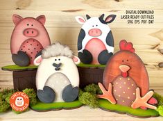 three ceramic farm animals sitting on top of green moss covered ground next to wooden planks