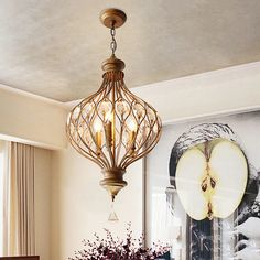 a chandelier hanging from the ceiling over a dining room table with flowers on it