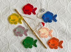 colorful felt fish on white quilt with wooden stick