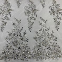 This beaded and sequined lace fabric is sure to bring couture style to any special occasion. Embroidered on 100% polyester net mesh, this elegant fabric is perfect for creating breathtaking quinceanera dresses, wedding gowns, formal evening dresses, and luxurious dance costumes. Available in four beautiful colors, this high-end lace fabric is embellished with beads and pearls for an exquisite, truly one-of-a-kind look. With this luxe lace fabric from Lace USA, your dream dress for any special ev Elegant Embroidered Net Tulle Fabric, Lace Embroidered Fabric For Reception, Elegant Net Sequin Fabric, Elegant Silver Sequin Fabric With Floral Embroidery, Elegant Silver Embroidered Organza Fabric, Elegant Embroidered Tulle Lace, Elegant Sequin Tulle Fabric With Floral Embroidery, Elegant Silver Embellished Embroidered Fabric, Elegant Embellished Embroidered Organza Fabric