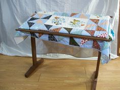 a wooden table with a patchwork quilt on it