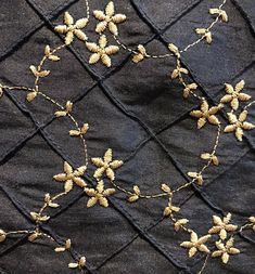 an embroidered piece of cloth with small flowers on the top and bottom, along with other fabric material