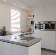 a modern kitchen with white cabinets and stainless steel counter tops is pictured in this image