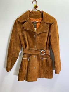 Absolutely stunning vintage suede leather jacket from the 1960s!  The details in this coat are just beautiful!  It nips in at the waist a bit and flares out slightly from the waist down.  Very flattering.  Very Woodstock!!  It features a four button snap closure and still has the original belt!  Two cute zippered pockets in the front. Made in Canada by Leather Wear I would say this is a size small or a small/medium. But please check measurements below to ensure a fit that works for you. Perhaps 70s Winter Outfits, 70s Fall Fashion, Vintage Leather Trench Coat, 70s Inspired Outfits, 70s Jacket, 70s Clothing, Suede Leather Jacket, Leather Wear, Suede Coat