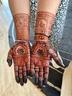 two hands with henna designs on them