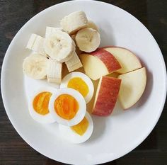 an apple, banana, and hard boiled egg on a plate with sliced up bananas