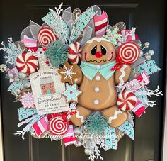 a christmas wreath with a gingerbread man and candy canes on the front door