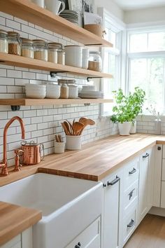 a kitchen with white cabinets and wooden counter tops, open shelving above the sink