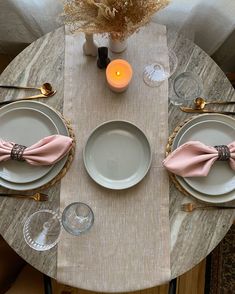 the table is set with two place settings, and there are candles on each plate