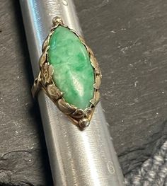 "Lovely hand wrought genuine green Jade Ring-Stamped 14K-Arts and Crafts-Art Nouveau from the early 1900s.  Condition is very good any slight wear commensurate with age-photos show the details.  small size  4 1/3, wt.- 5.3 grams, approx 1\" north to south on finger.  The ring was made by hand with a floral setting, the navette cabochon Jade is approx. 22mm by 9mm.  Truly an enchanting creation." Heirloom Green Emerald Oval Cabochon Ring, Heirloom Green Oval Cabochon Emerald Ring, Antique 14k Stamped Emerald Ring, Antique Emerald Ring Oval Cabochon, Antique Emerald Ring With Oval Cabochon, Collectible Green 14k Stamped Jewelry, Antique Green Ring With 17 Jewels, Antique Green Jewelry Stamped 14k, Vintage Hallmarked Emerald Jewelry